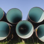 Large metal pipes stacked in field for new water aquaduct project